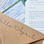 Brown paper with 'Hello April' text on a background of printed pages.