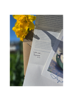 a letter and an art print with a daffodil
