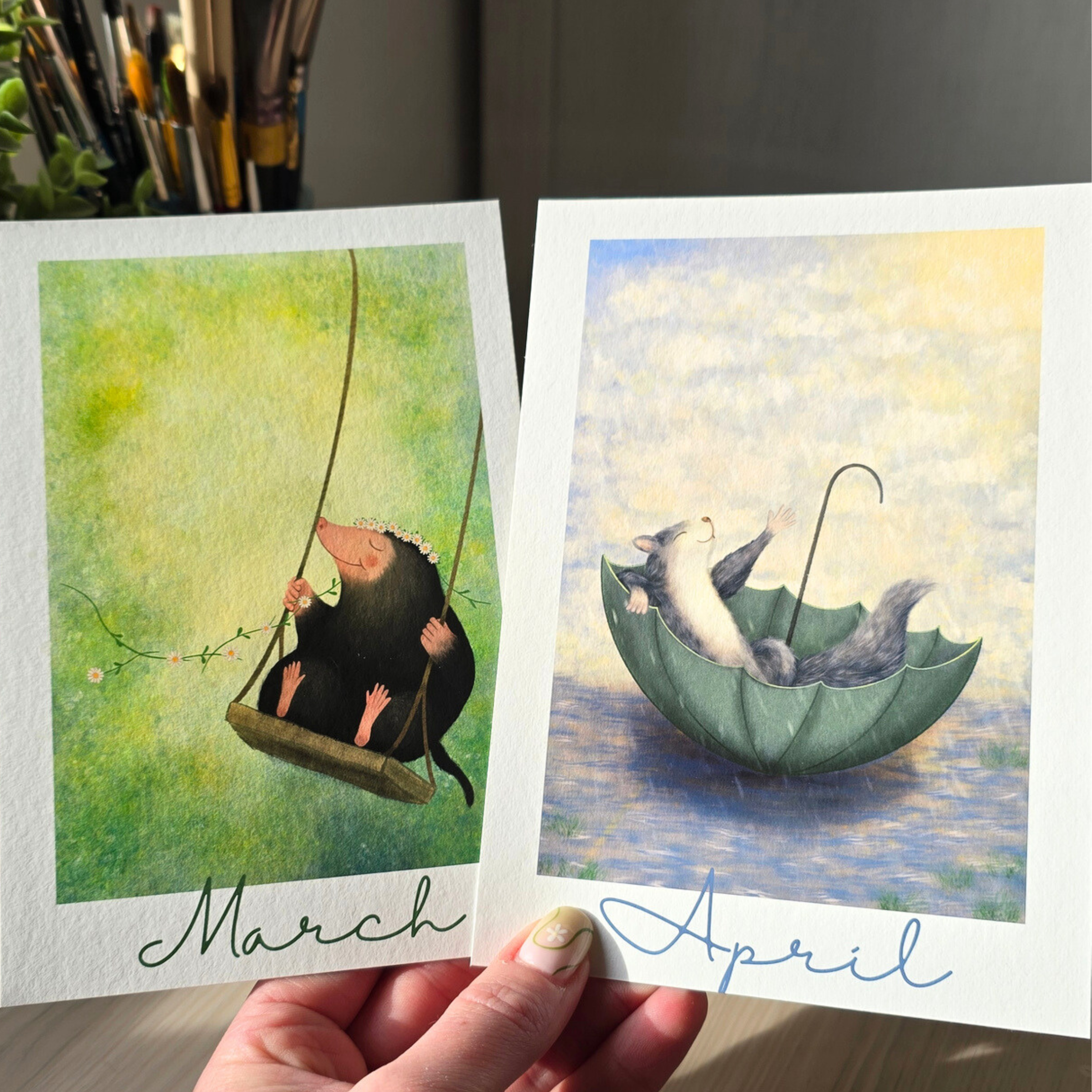Two greeting cards titled 'March' and 'April' with illustrations of a mole and a squirrel